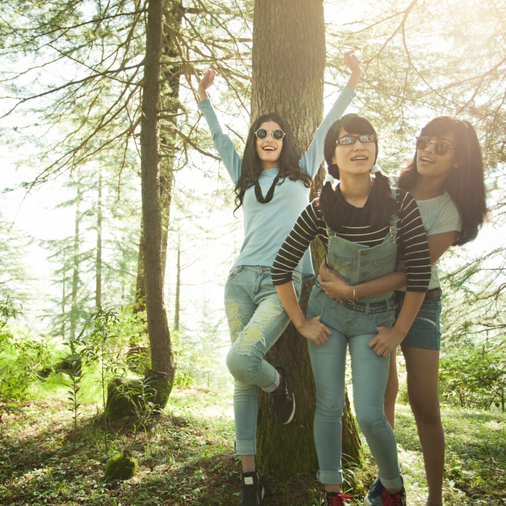 Happy female friends of different ethnicity doing fun in nature.